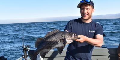 person holding a black rockfish